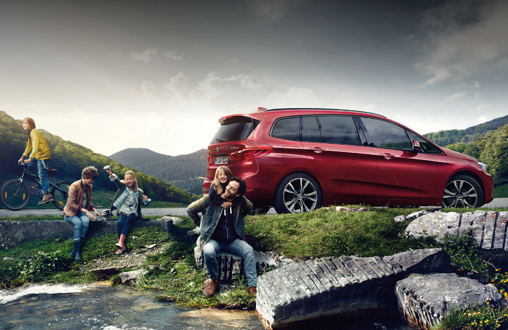 Carefree family that uses BMW Financial Services playing by a stream