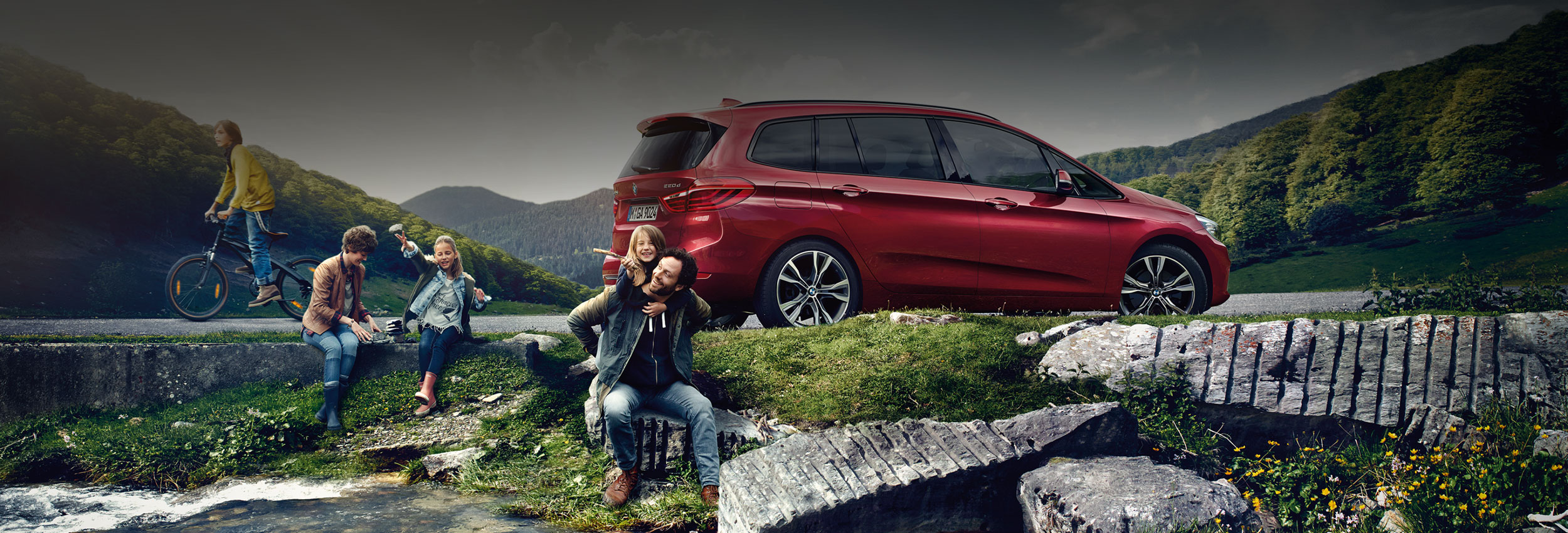 Carefree family that uses BMW Financial Services playing by a stream